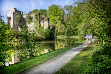 Vrouw en man wandelen langs de ruïnes van het Prinsenkasteel in Grimbergen.