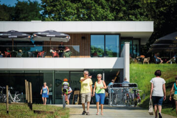 Mensen wandelen aan de ingang van het Sven Nys Cycling Center.