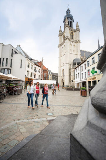 Drie vrouwen wandelen op het plein voor de kerk.