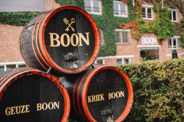 Drie biervaten van de brouwerij buiten opgestapeld.