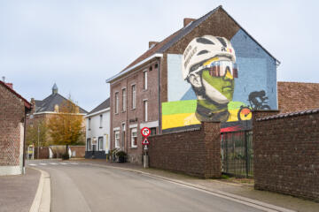 Muurschildering van wielrenner Remco Evenepoel op de gevel van een huis.
